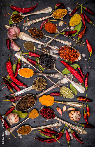 Fototapeta Naklejka Na Ścianę i Meble -  Various spices spoons on stone table. Top view .