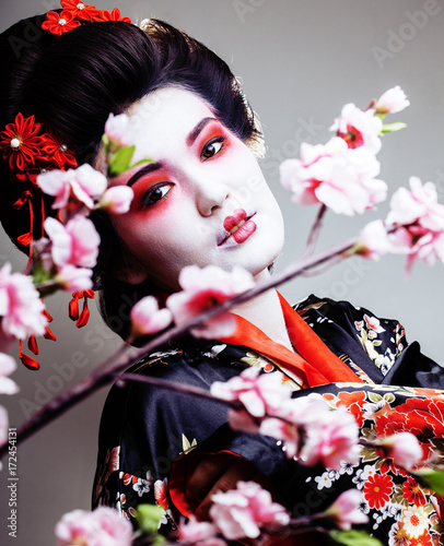 young pretty geisha in kimono with sakura and red decoration des