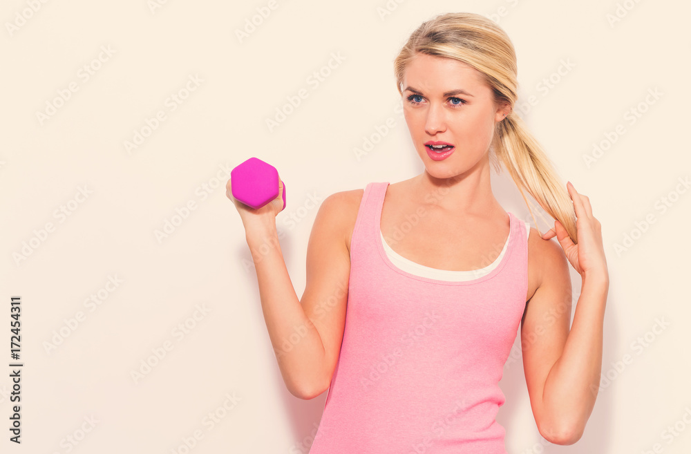 Young blonde woman working out with a dumbbell Young blonde woman working out with a dumbbell