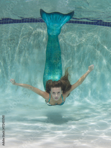 Beautiful young women in a swimsuit, or mermaids tail above and below the water.
