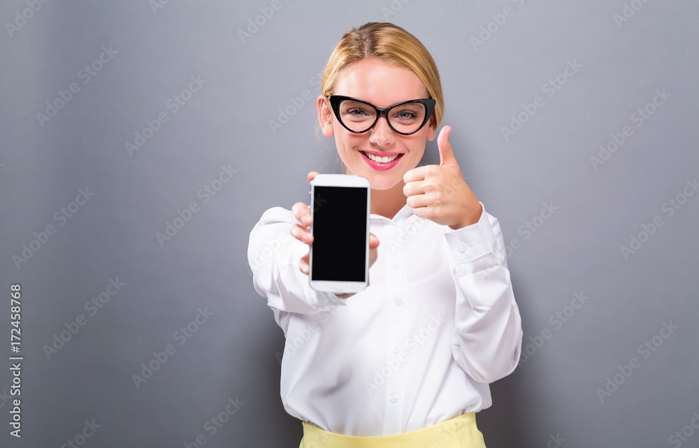 Young woman holding out a cellphone in her hand