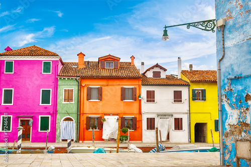 Colorful houses in Burano island with cloudy blue sky near Venice, Italy. Popular and famous tourist place