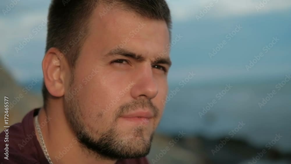 Portrait Young man sits on beach in summer evening outdoors. Portrait Young man sits on beach in summer evening outdoors.