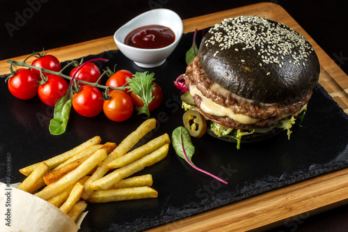 Black double hamburger made from beef with jalapeno pepper, cheese and vegetables-3 photo