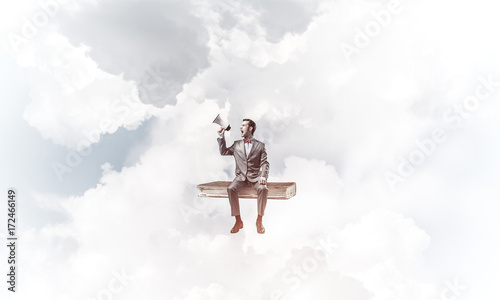 Businessman floating in blue sky and announcing something in lou