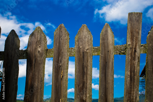 Vintage fence of old wooden planks against the blue sky. Background concept
