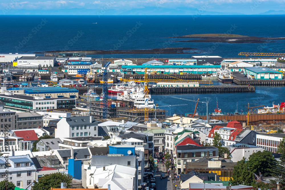 Beautiful super wide-angle aerial view of Reykjavik, Iceland with harbor and skyline mountains and scenery beyond the city, seen from the observation tower of hallgrimskirja