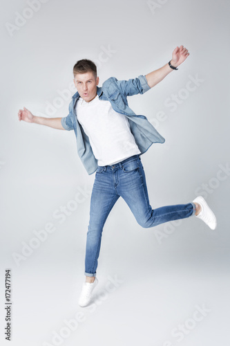  handsome man in jeans and jacket jumping