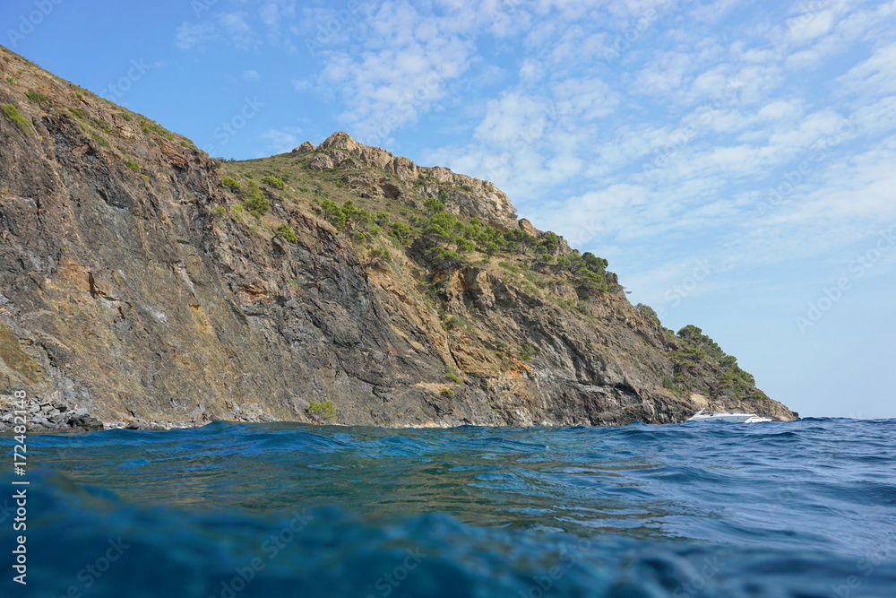Coastal cliff seen from water surface, Cap Norfeu, Mediterranean sea, Spain Costa Brava
