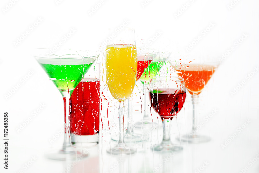 Seven cocktail and wine glasses with color drinks on the reflecting surface. Seven cocktail and wine glasses with color drinks on the reflecting surface.
