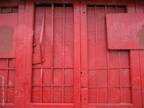 closeup of a red painted wooden door and window