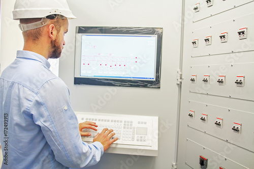 engineer remotely controls  technological process from dispatcher control panel. SCADA system. photo