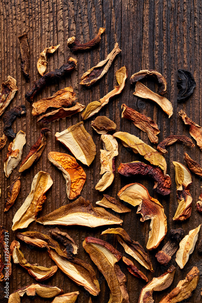 Dried forest mushrooms sliced on wooden background, top view Dried forest mushrooms sliced on wooden background, top view