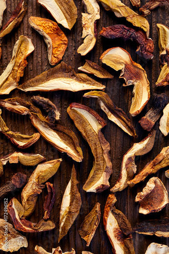 Dried forest mushrooms sliced on wooden background, top view