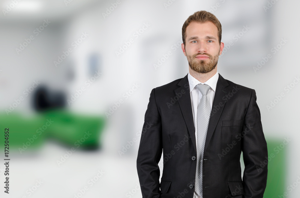 Portrait of young businessman standing in office Portrait of young businessman standing in office