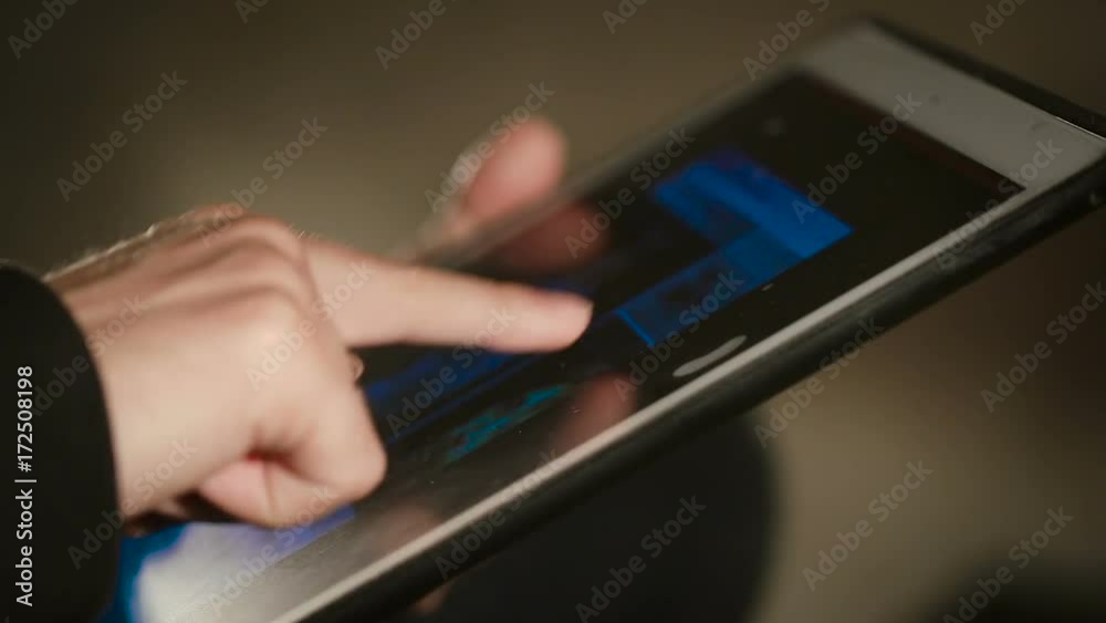 Closeup shot of man's hand scrolling and scaling On His Tablet Closeup shot of man's hand scrolling and scaling On His Tablet