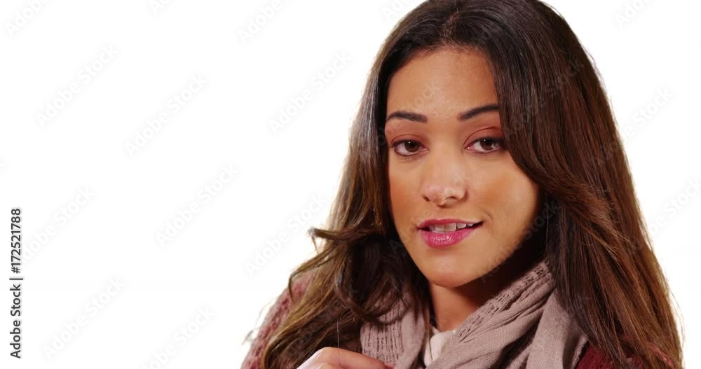 Close up of beautiful Latina looking at camera confidently on white background with copyspace. Portrait of Hispanic female with brown hair and eyes smiling at camera in studio with copy space. 4k Close up of beautiful Latina looking at camera confidently on white background with copyspace. Portrait of Hispanic female with brown hair and eyes smiling at camera in studio with copy space. 4k
