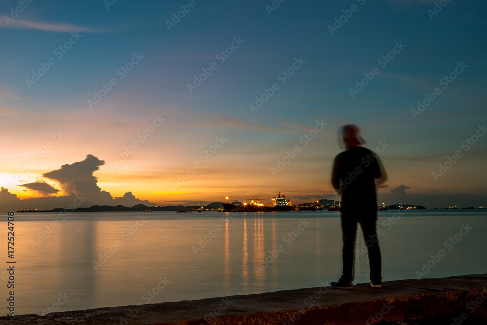 fishing man and beautiful sunset skies at coastal port