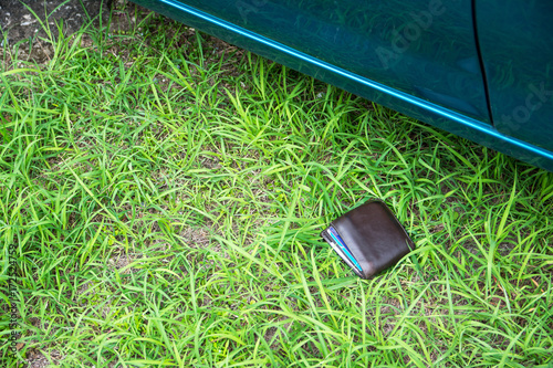 Wallet drop on grass beside the car
