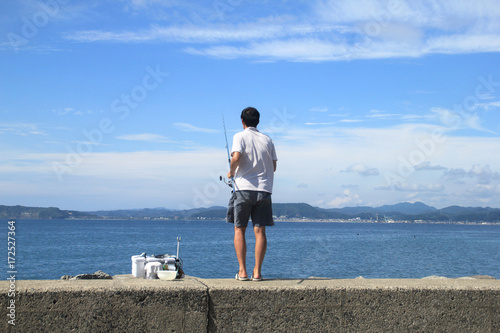 青空のもと海釣りをする男性｜Fisherman　Sea fishing person