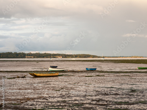 estuary scene in manningtree with moored boats tide clouds landscape photo