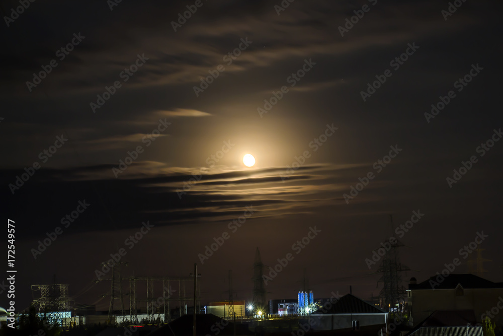 Fototapeta premium Moon, clouds over the village