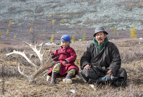 tsaatan nomadic boy and his grandfather in a traditional deels resting