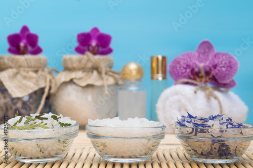 three plates with sea salt  against the background of purple orchids SPA