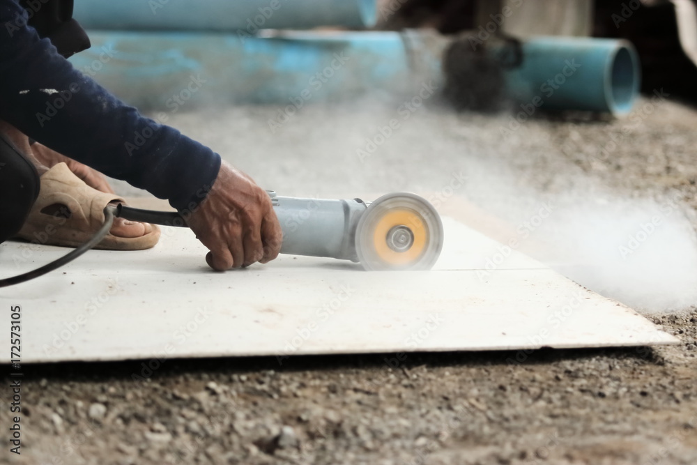 Hands of heavy industry worker with angle grinder cutting concrete. Stock  Photo | Adobe Stock