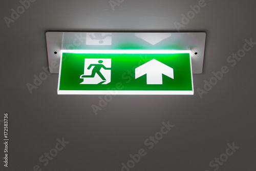 green emergency exit sign showing the way to escape.