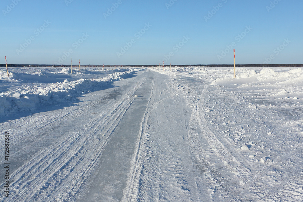 Ice road in snow on the frozen water reservoir in the winter, the Ob River, Siberia, Russia