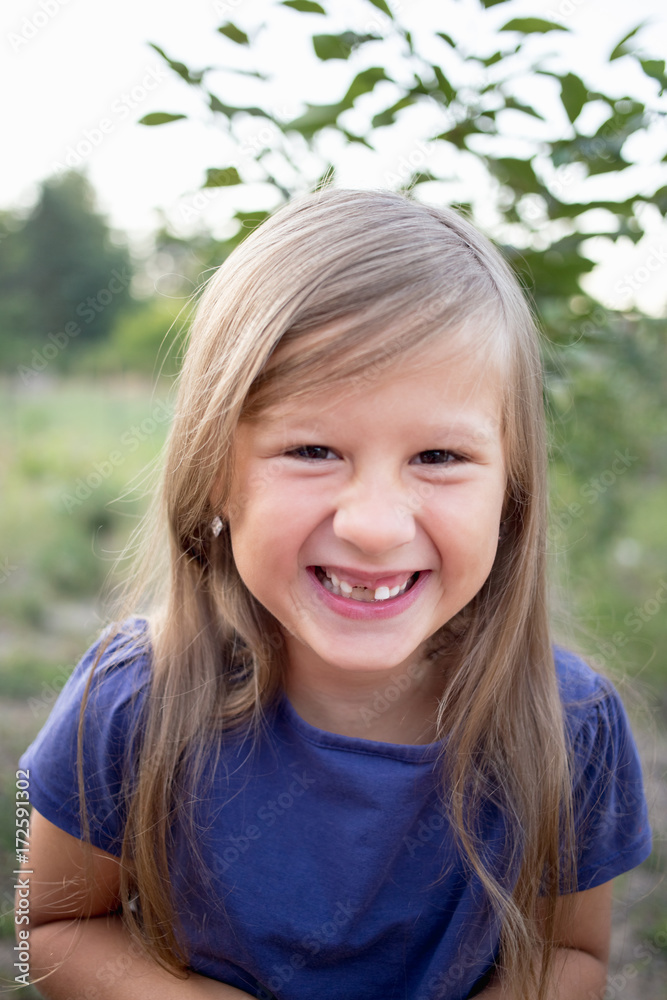 Young little girl without a front tooth in the countryside Young little girl without a front tooth in the countryside