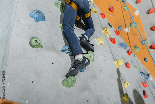 little boy climbing wall with grips