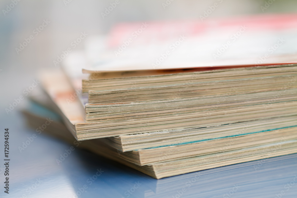 Time to read concept. Pile of stacked magazines on the blur background. Closeup, selective focus Time to read concept. Pile of stacked magazines on the blur background. Closeup, selective focus