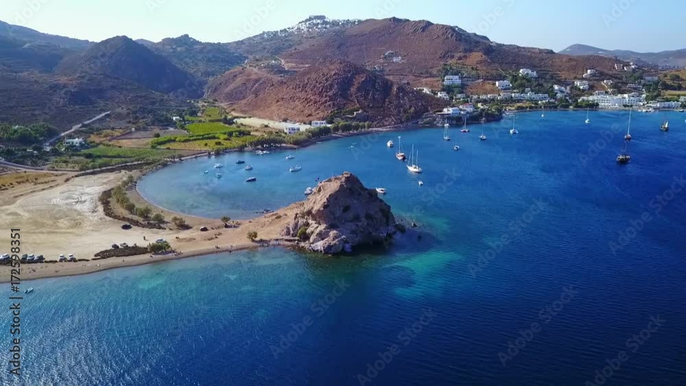 August 2017: Aerial drone video of famous rock of Kalikatsou in Petra beach with turquoise clear waters, Patmos island, Dodecanese, Greece August 2017: Aerial drone video of famous rock of Kalikatsou in Petra beach with turquoise clear waters, Patmos island, Dodecanese, Greece