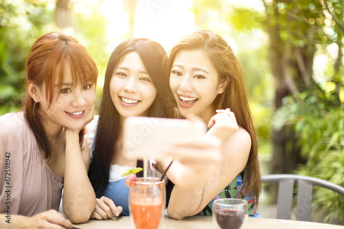 Group of friends taking selfie in garden restaurant