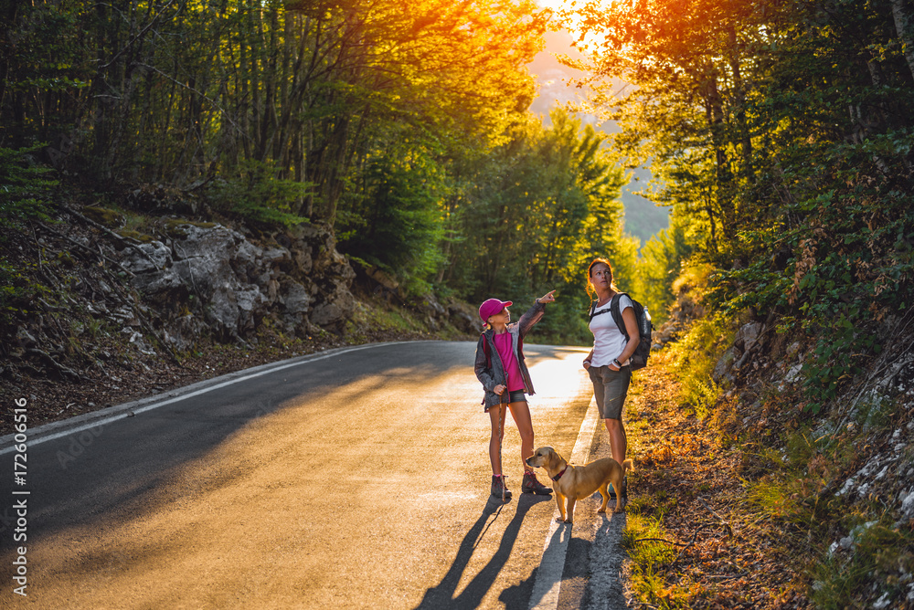 Fototapeta premium Mother and daughter Hiking by the asphalt road