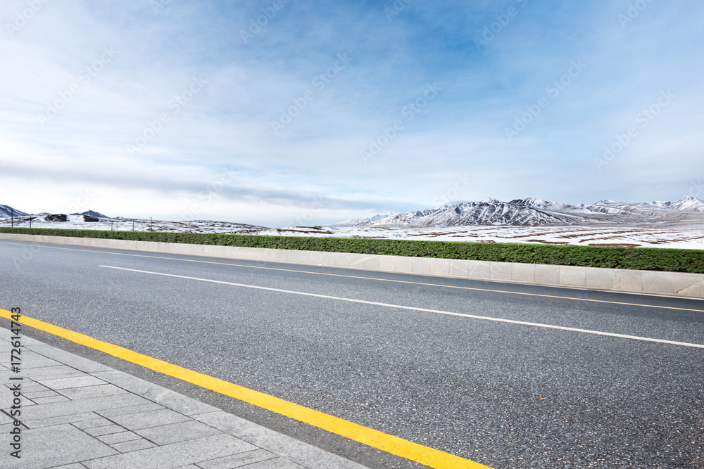 Fototapeta premium empty asphalt road with beautiful snow mountains