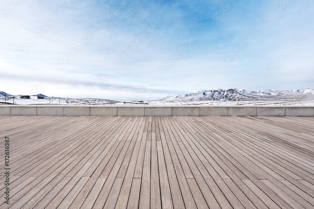 empty wooden floor with beautiful snow mountains empty wooden floor with beautiful snow mountains