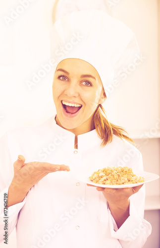 portrait of young coosie woman showing mush at kitchen photo