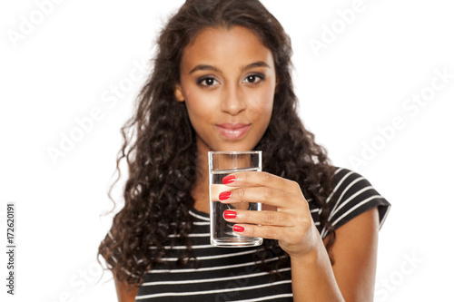 young beautiful african girl holding a galass of water on white background photo