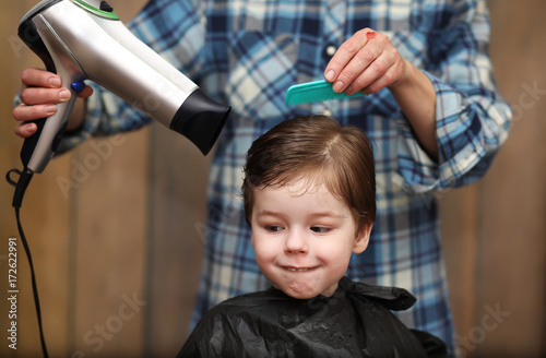 A little boy is trimmed in the hairdresser's bright emotions on face