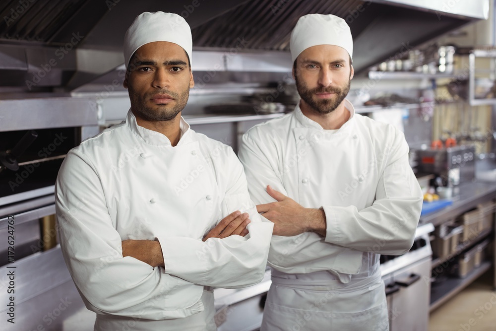 Portrait of two chefs standing together with arms crossed in
