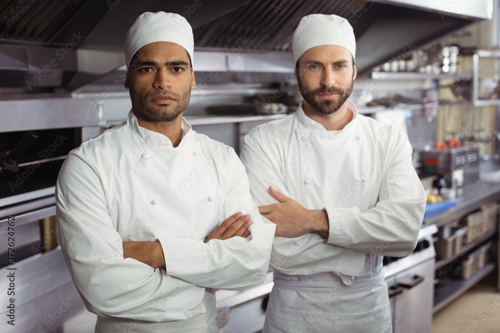Portrait of two chefs standing together with arms crossed in Portrait of two chefs standing together with arms crossed in