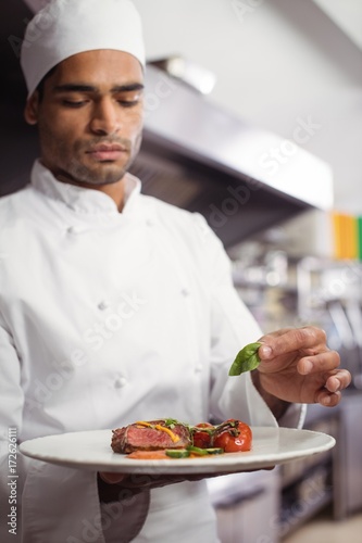 Chef holding delicious dish in kitchen