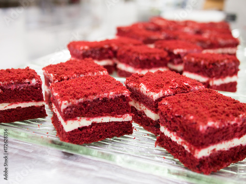 Close-up, Red velvet cake is delicious with several pieces of red and white layers on a clear glass plate.