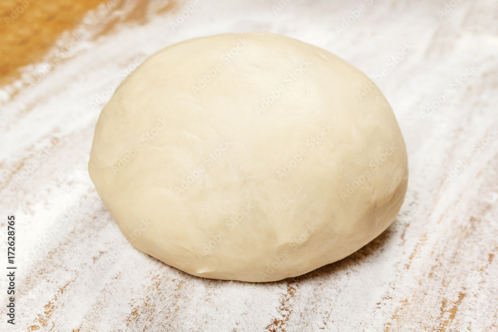 Raw dough on wooden board