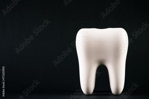 White healthy human tooth isolated on a black