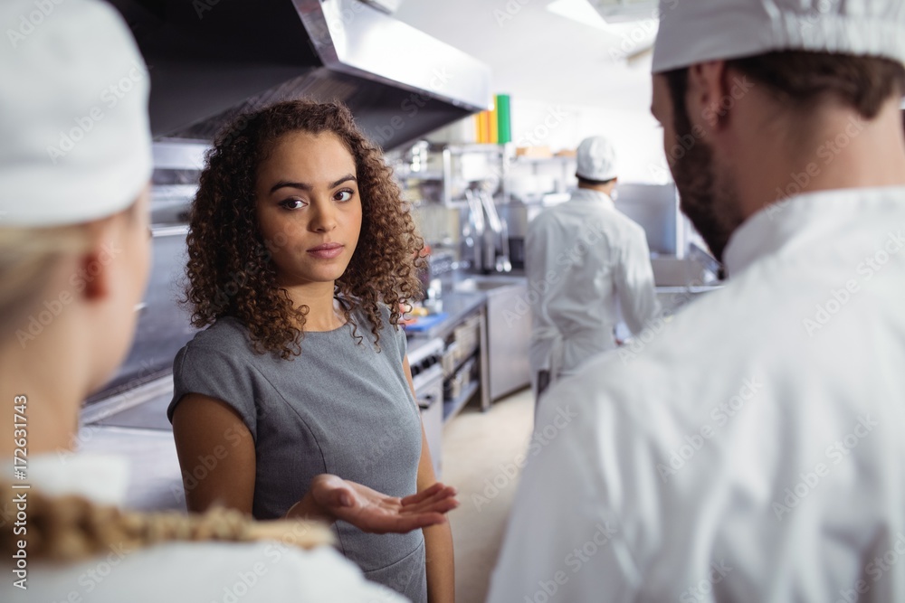 Fototapeta premium Restaurant manager interacting with his kitchen staff