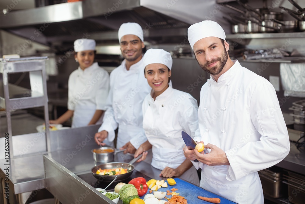 Chefs chopping vegetables on chopping board in the commercial Chefs chopping vegetables on chopping board in the commercial